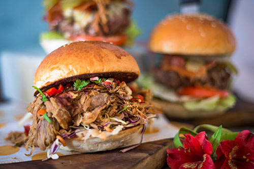 Burger on menu at World Bar with juicy pulled pork 3 burgers pictured