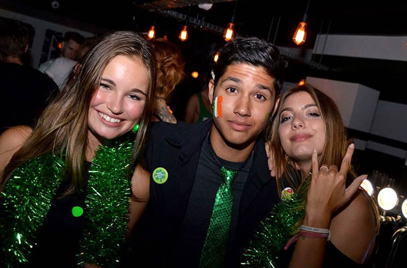 2 females and one male on St Paddy's day pub crawl party in Queenstown Why doesn't he look happier?