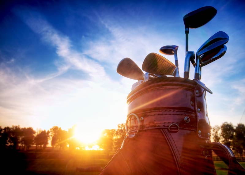 Golf clubs at sunset