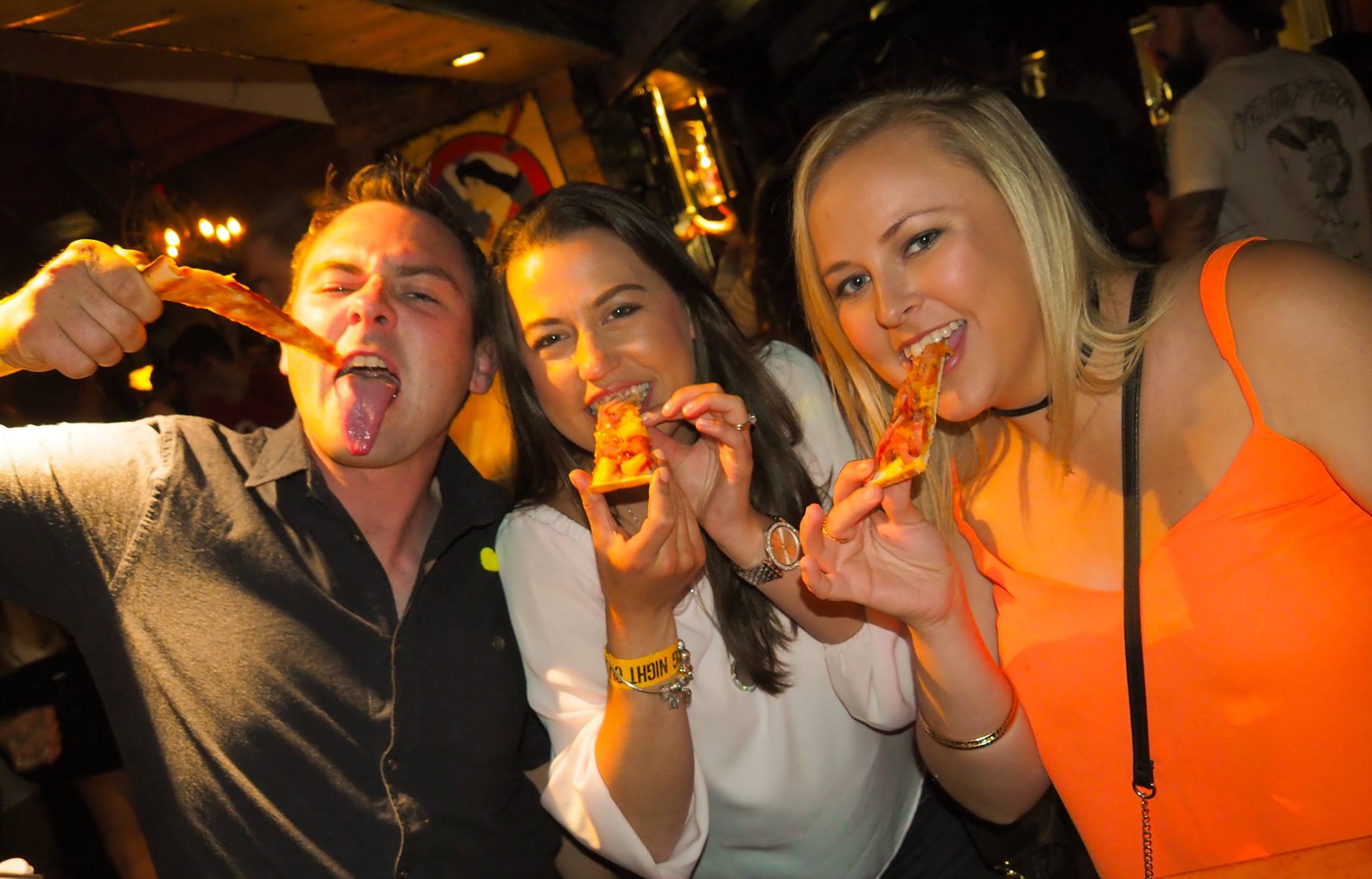 guests on the big night out pub crawl eating the free pizza given out on Saturday in Queenstown