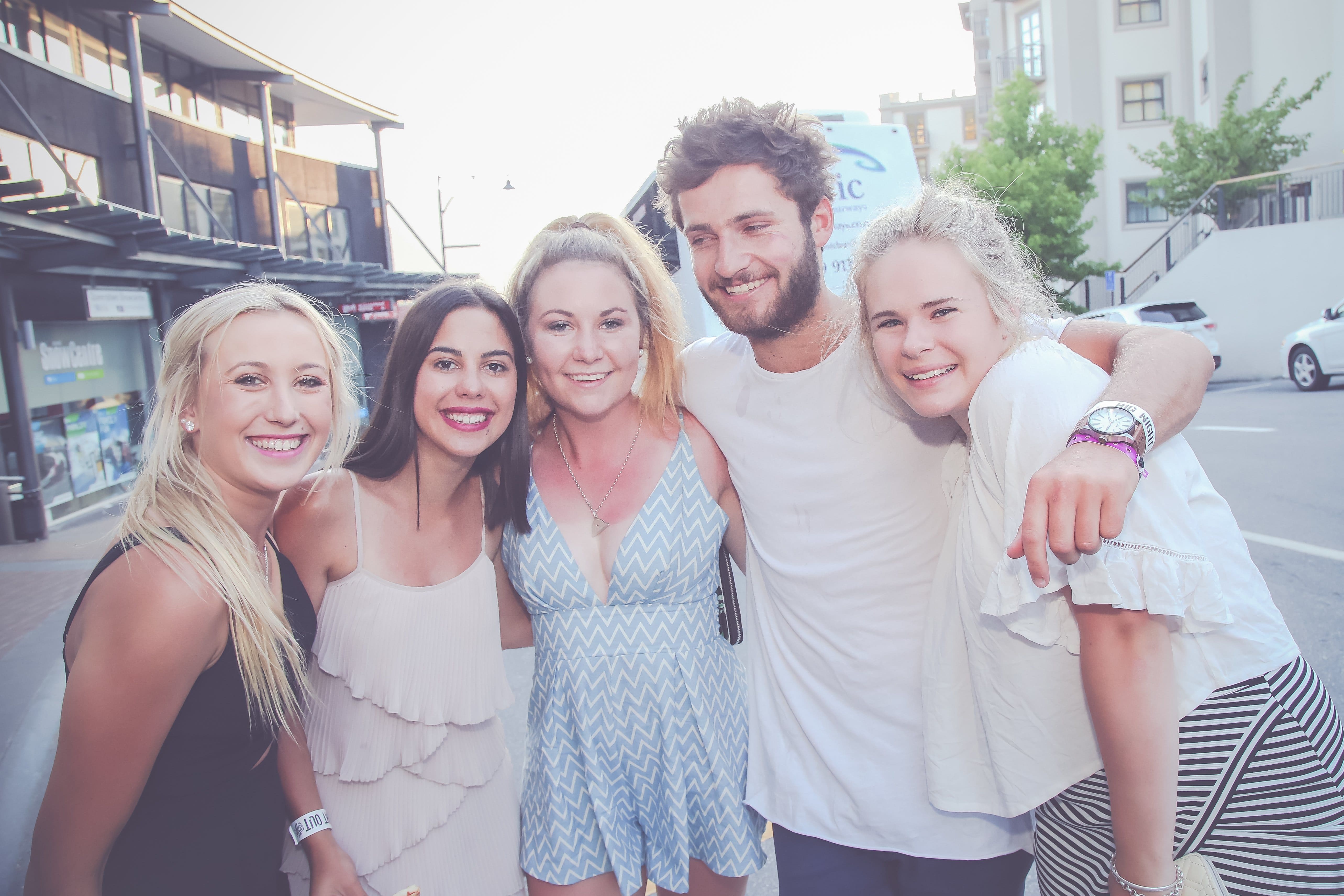 Guy partying with four girls on the big night out pub crawl in Queenstown for New Year weekend