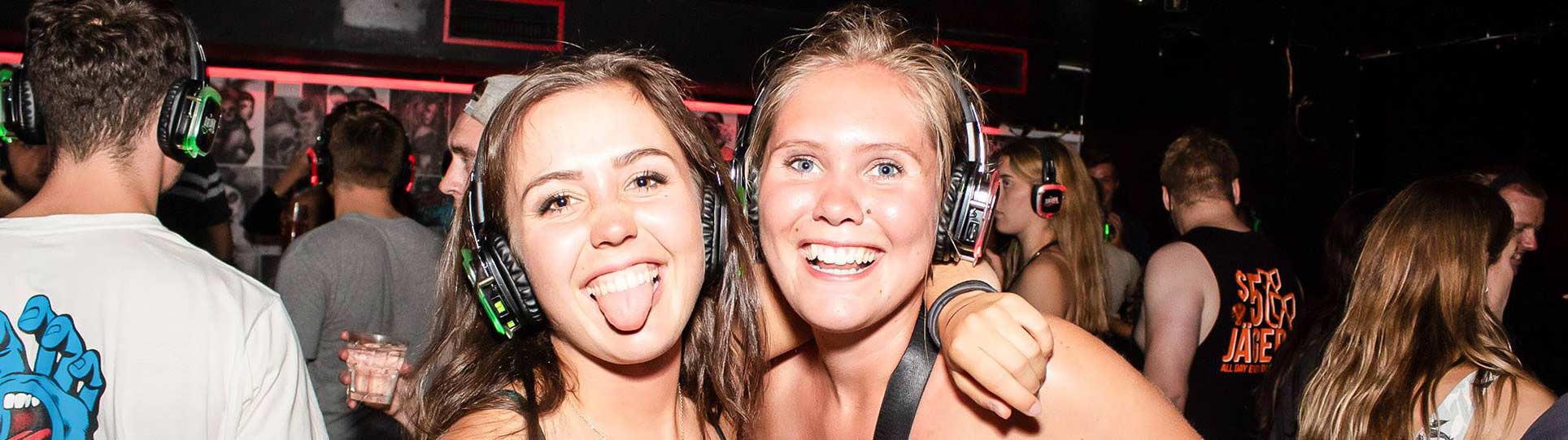 Two girls enjoying the Silent Disco on the Big Night Out Pub Crawl in Queenstown New Zealand on a Wednesday night